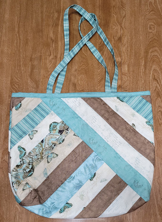 Quilted bag with butterfly pattern on a wooden surface