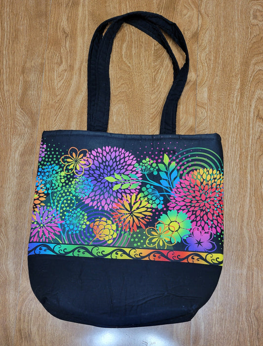 Black bag with colorful floral pattern on a wooden surface