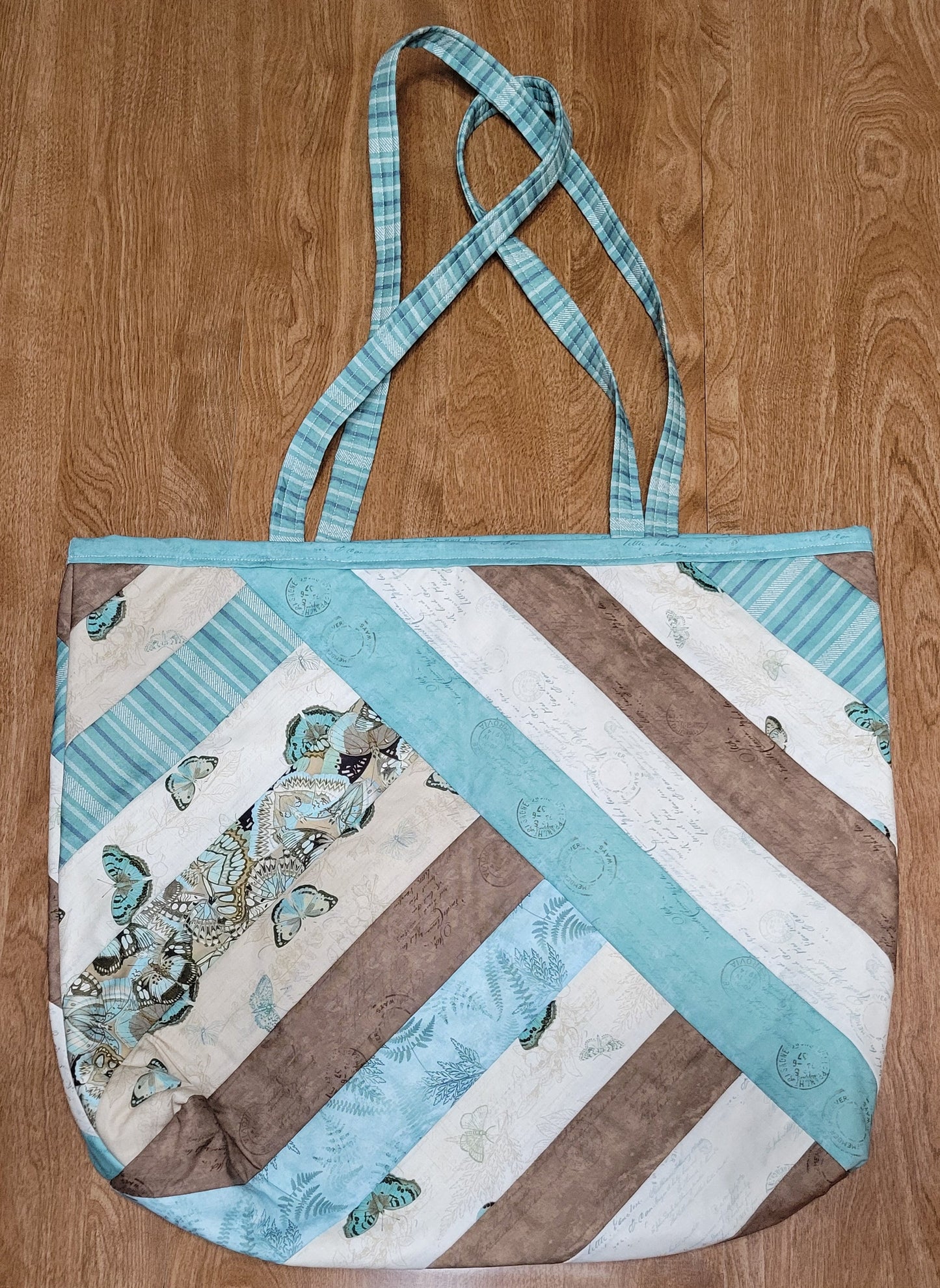 Quilted bag with butterfly pattern on a wooden surface