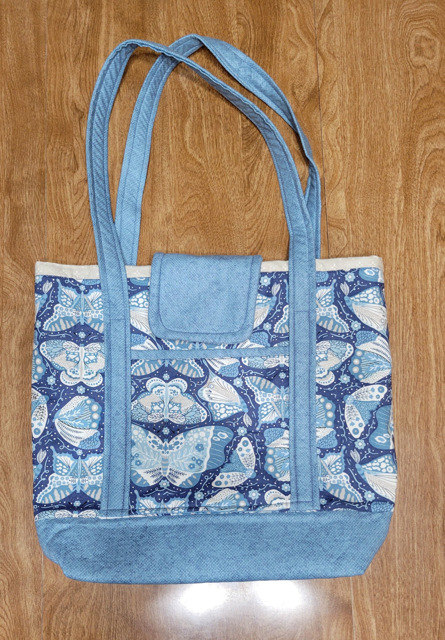 Blue butterfly-patterned bag on a wooden surface