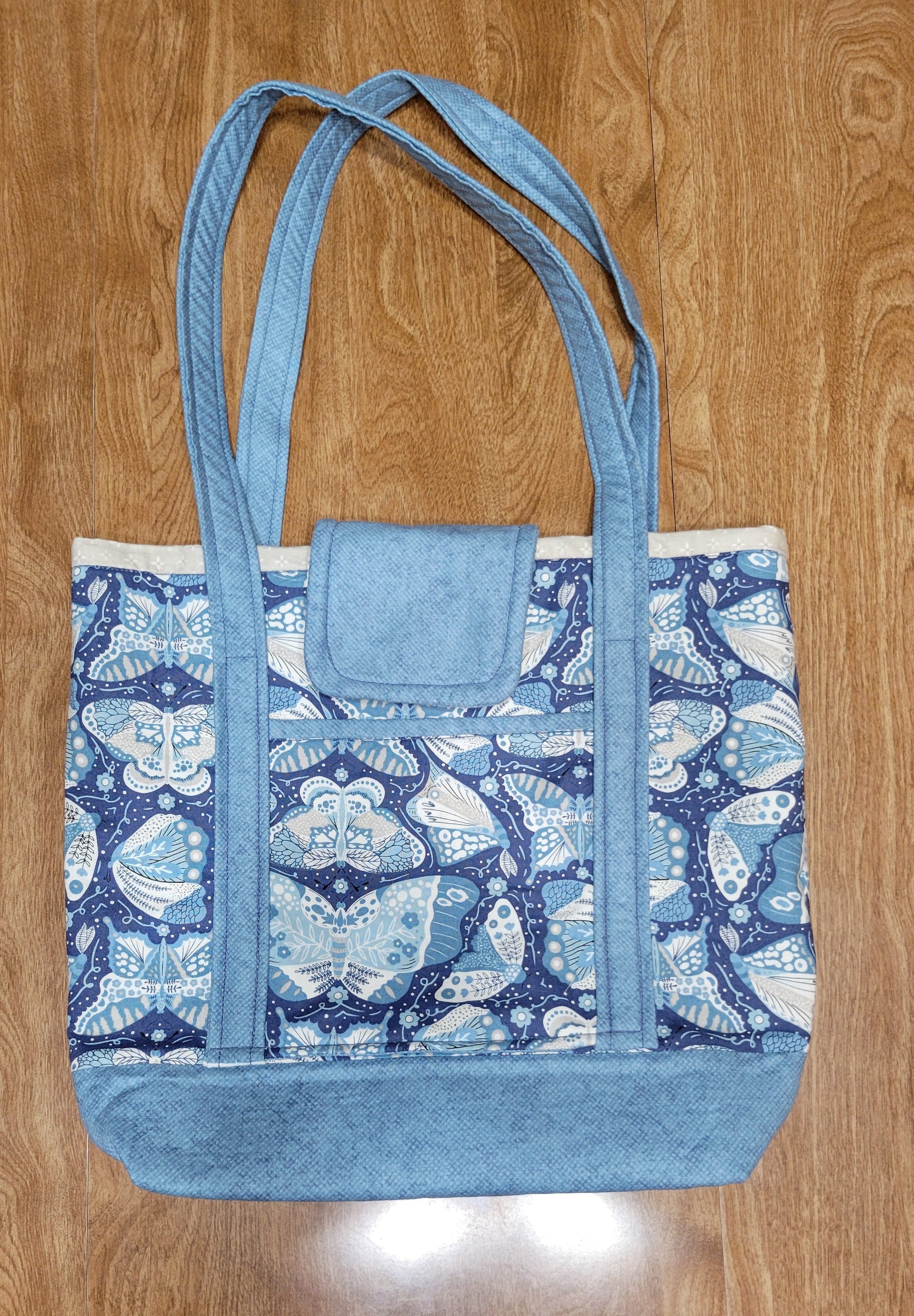 Blue butterfly-patterned bag on a wooden surface