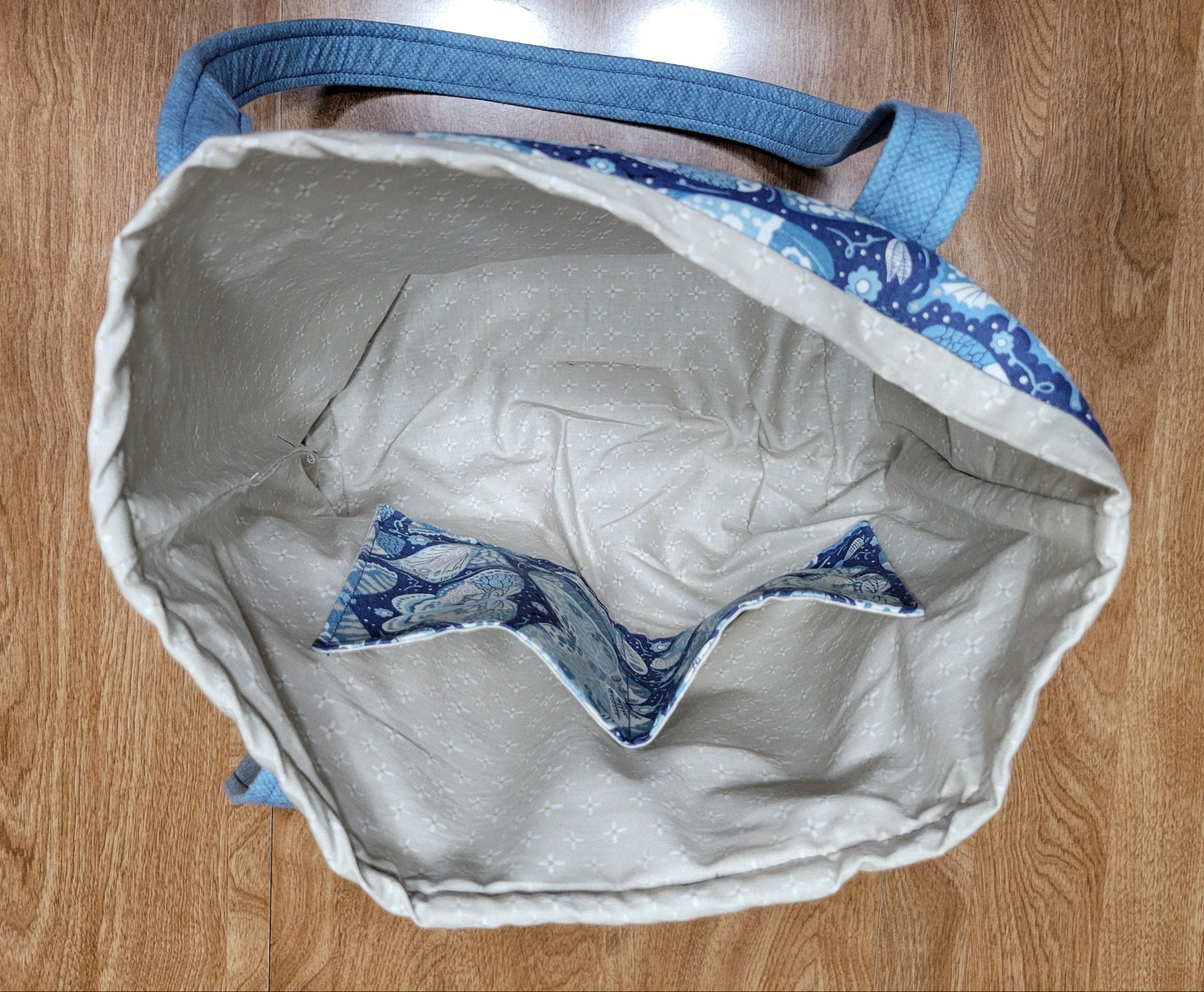 Gray tote bag with blue butterfly pattern on a wooden surface