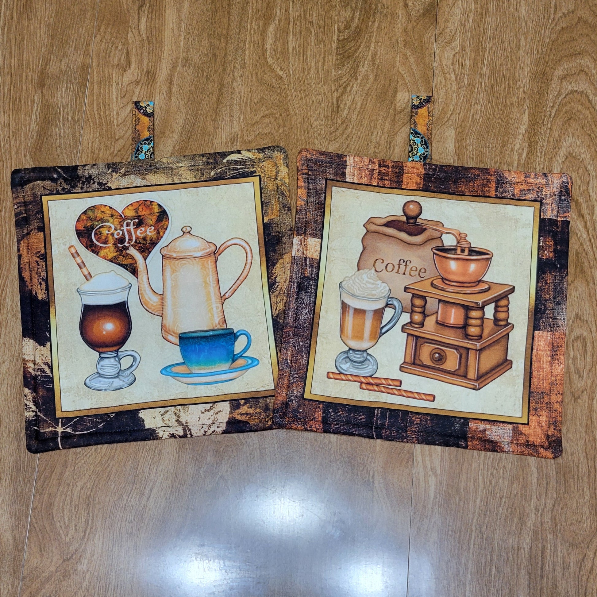 Two coffee-themed pot holders with a brown, black, and golden border on a wood surface