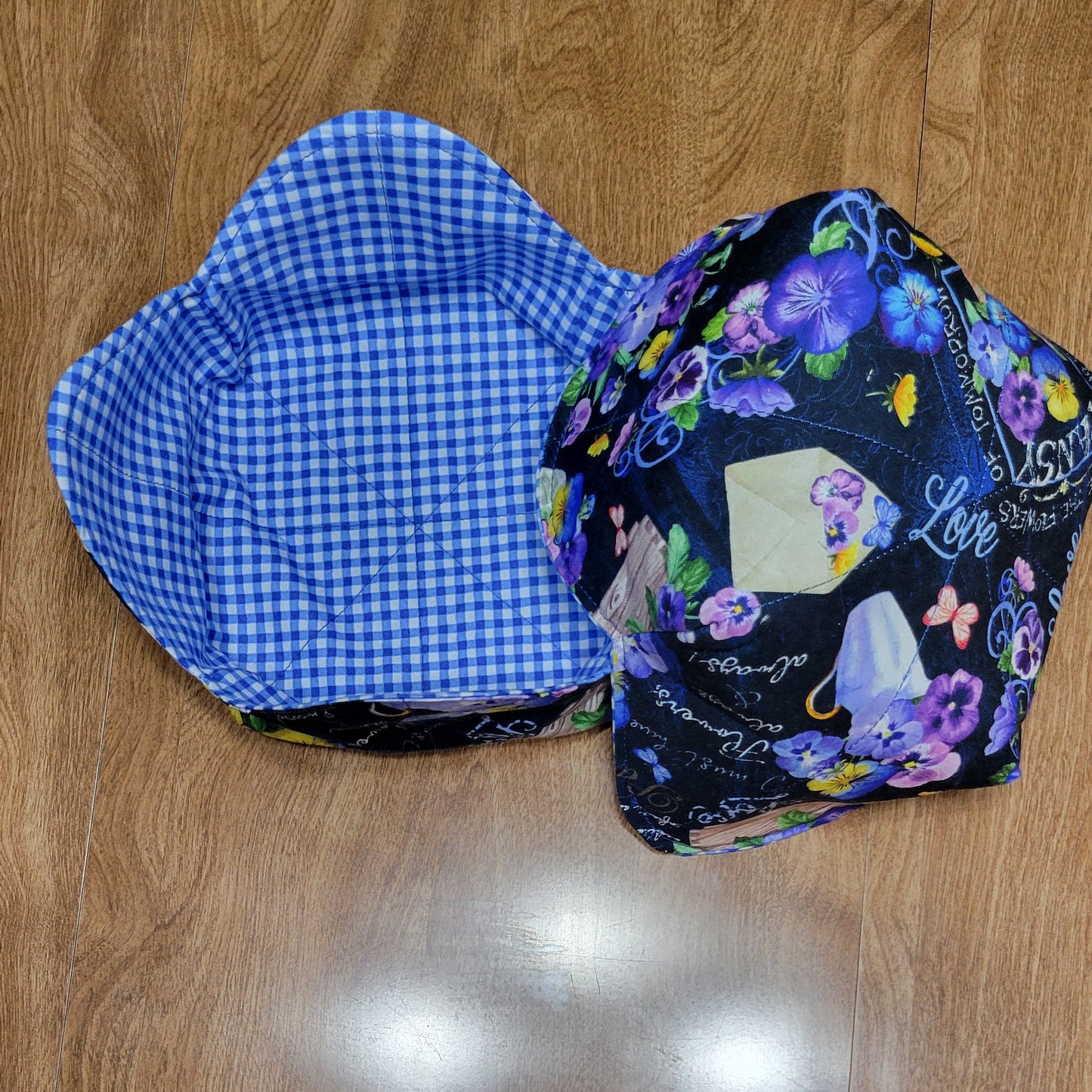Floral-patterned with a blue and white checkered inside on a wooden surface.