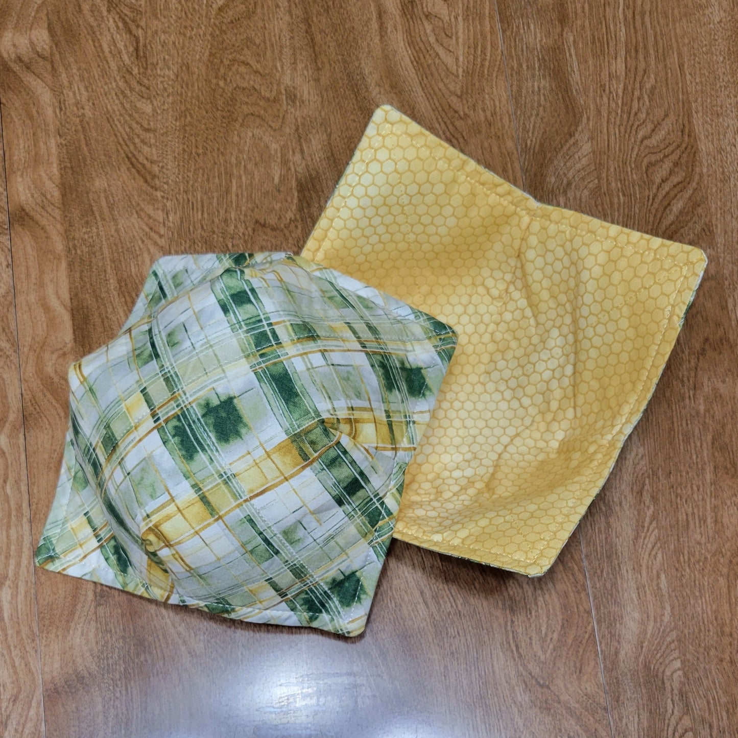 Two cloths, one green and one yellow, on a wooden surface.