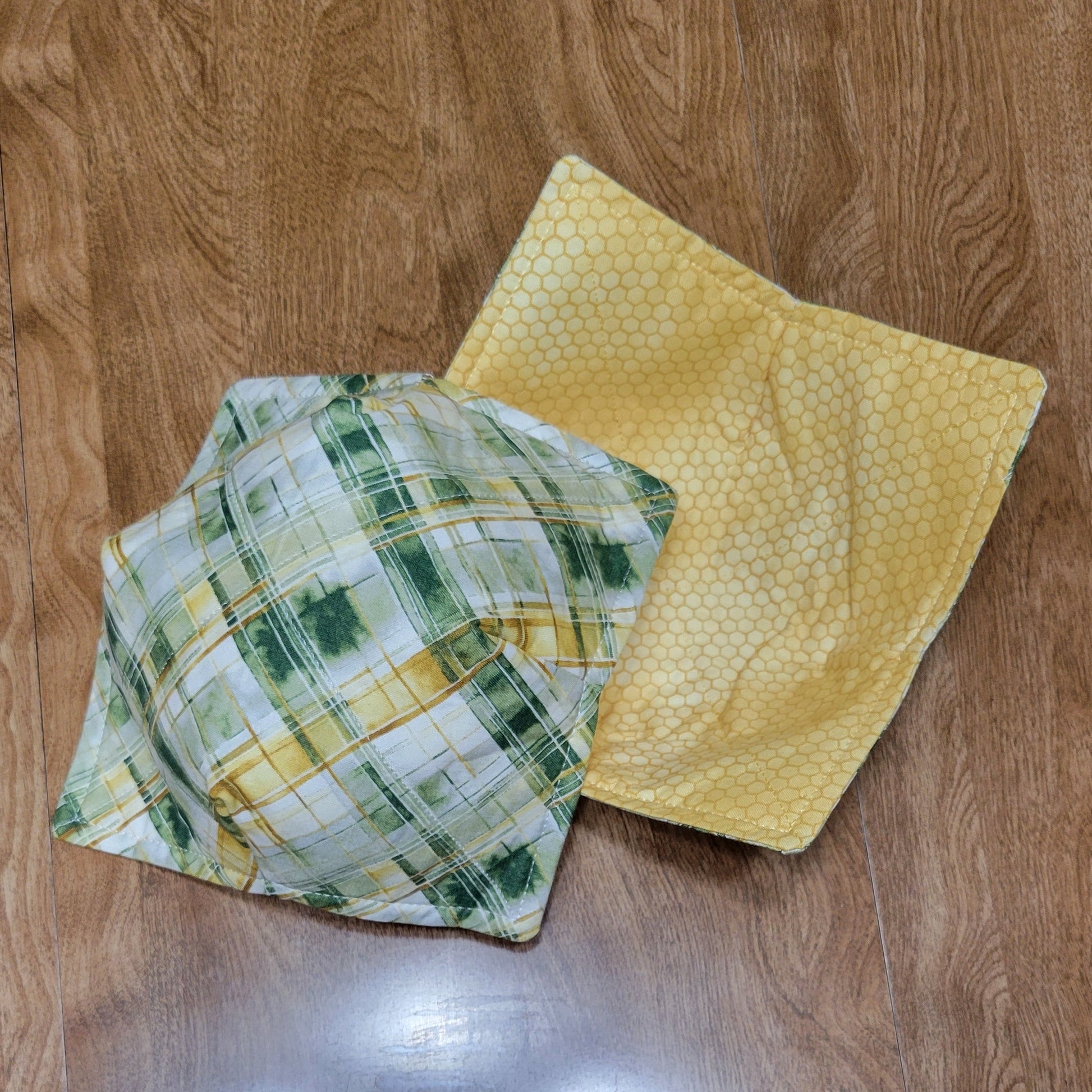 Two cloths, one green and one yellow, on a wooden surface.