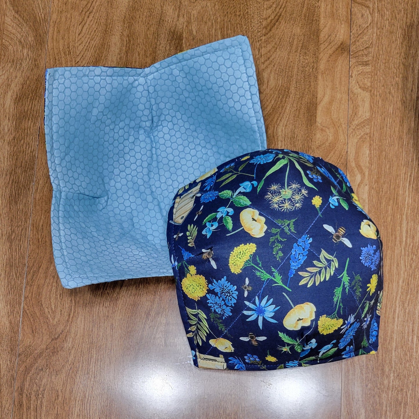 Navy blue scrub cap with floral pattern on a wooden surface