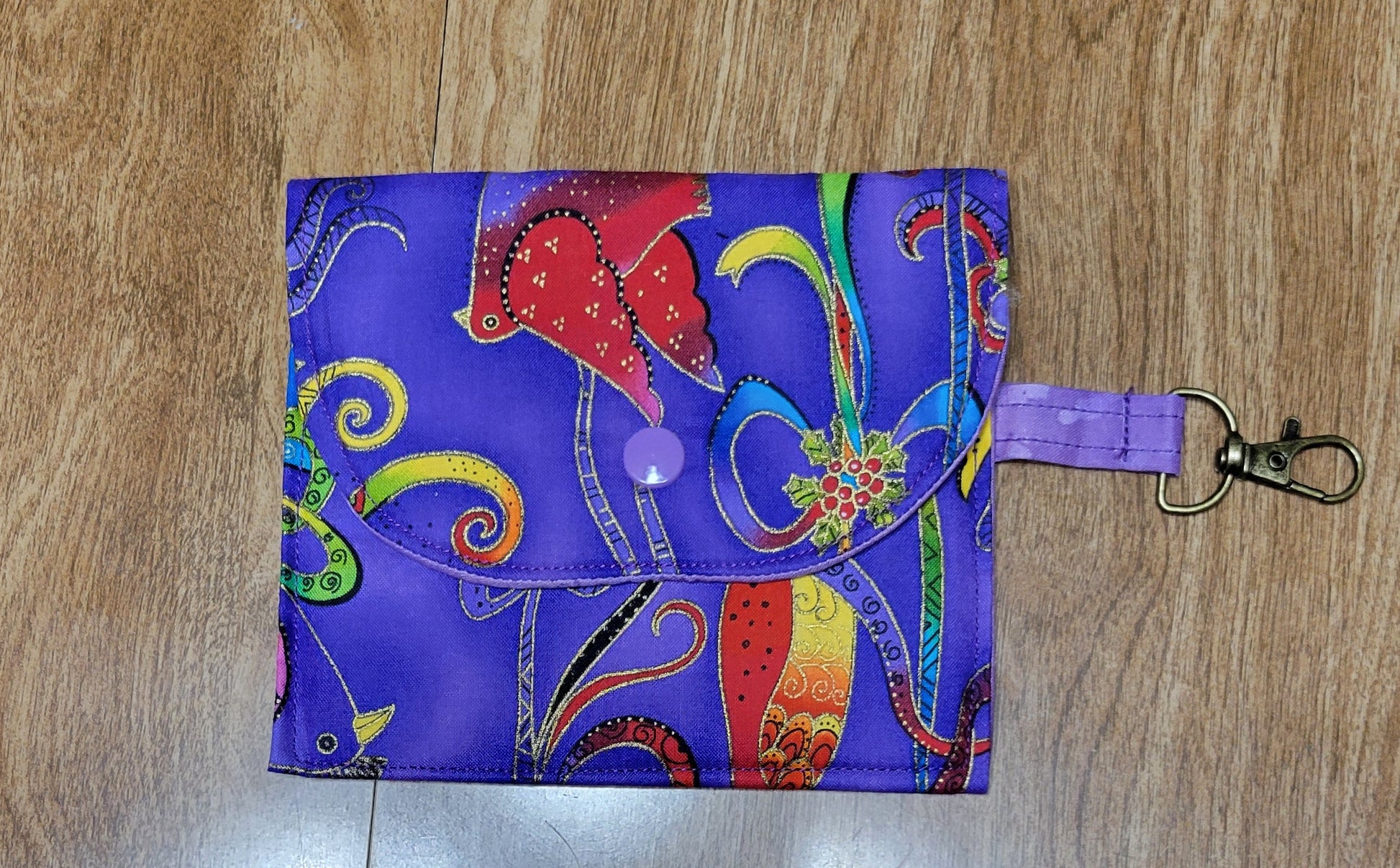Colorful fabric pouch with a keychain clip on a wooden surface