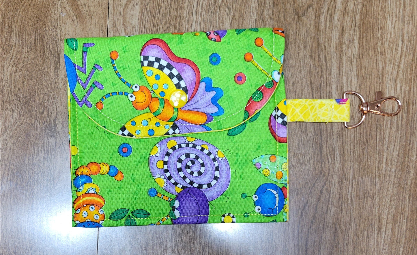 Colorful keychain pouch with cartoon designs on a wooden surface