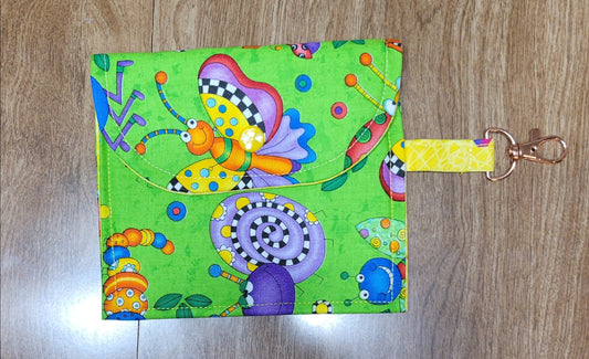 Colorful keychain pouch with cartoon designs on a wooden surface