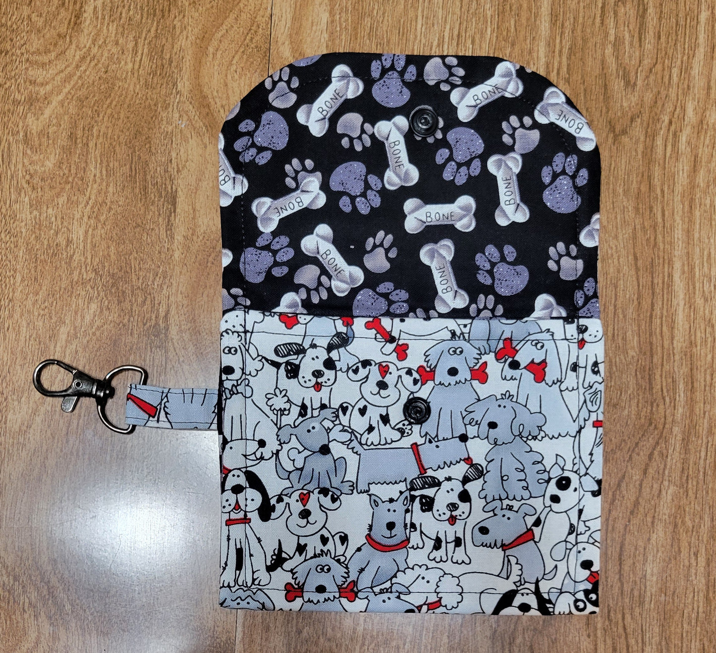 Two patterned dog themed pouch on a wooden background with a keychain.