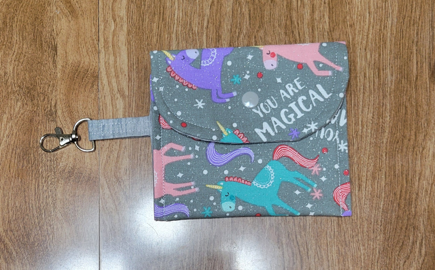Gray wallet with magical unicorn fabric with a wooden background