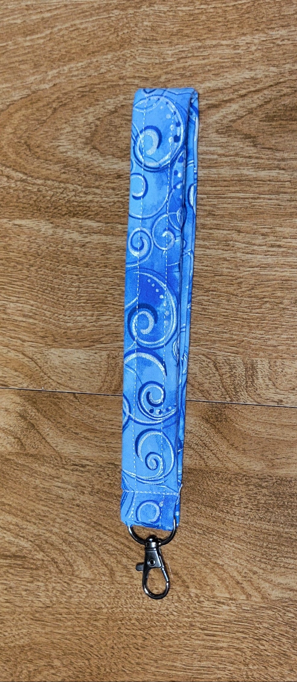 Blue swirl landyard on a wooden surface