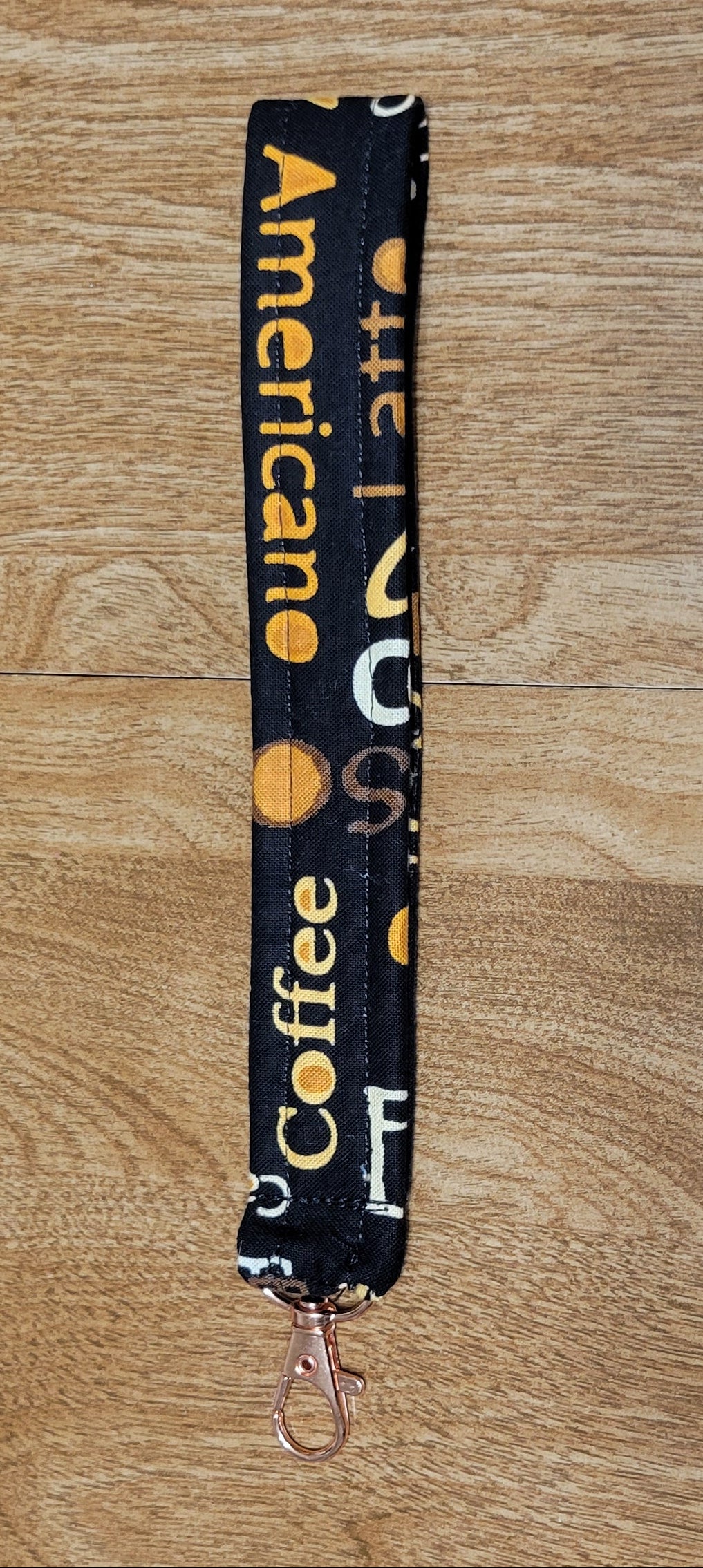 Lanyard with 'American Coffee' wording on a wooden surface