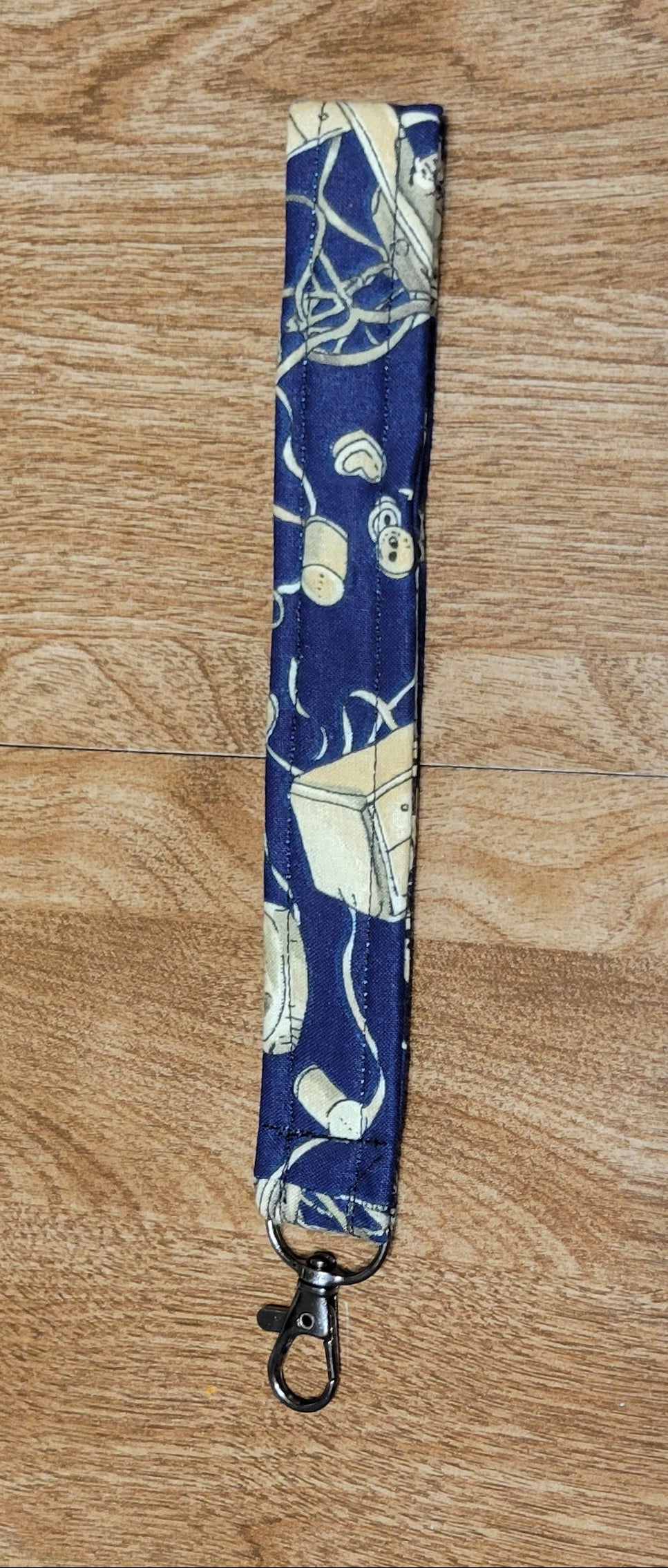 Blue sewing-patterned strap on a wooden surface