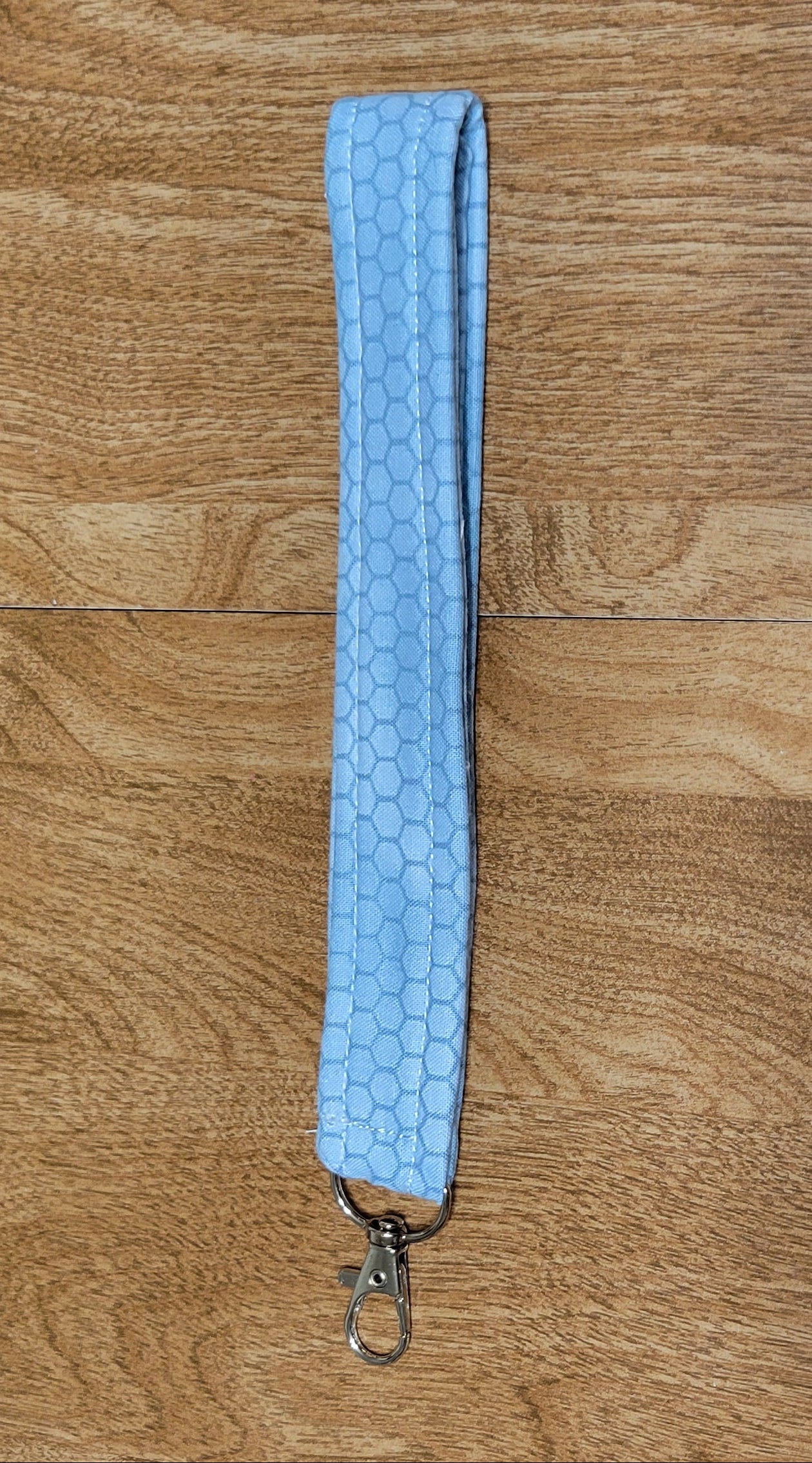 Blue strap with a metal buckle on a wooden surface