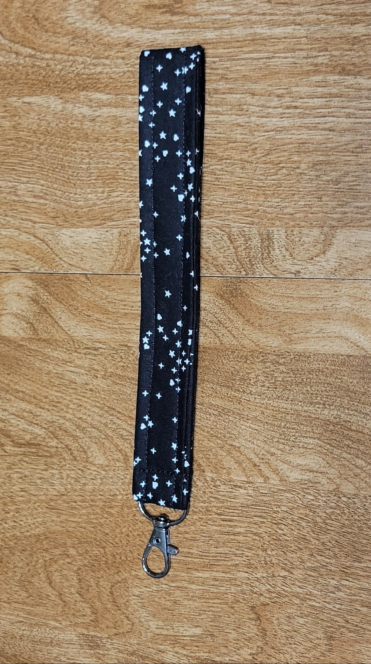 Black starry lanyard on a wooden surface