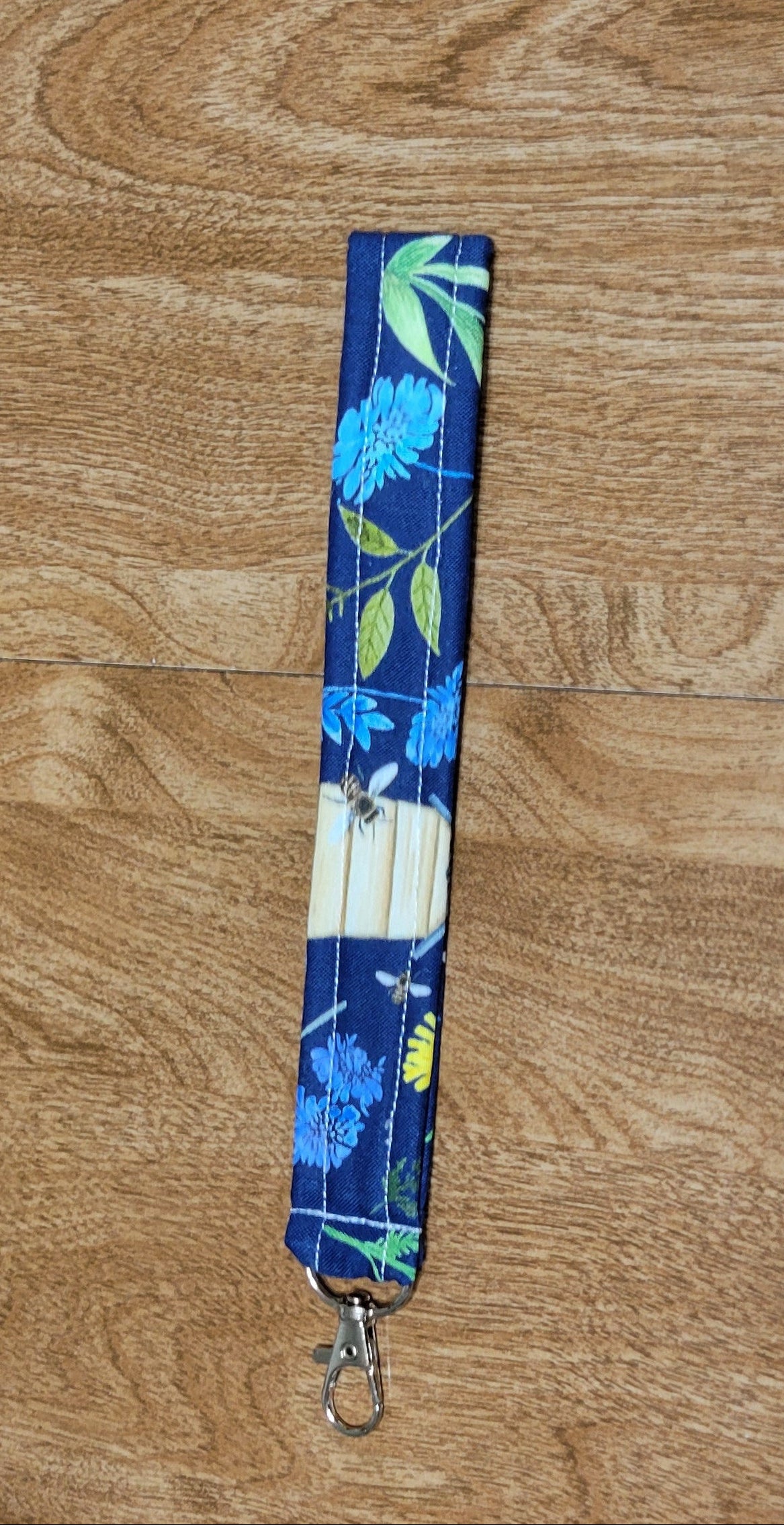 Floral-patterned lanyard on a wooden surface