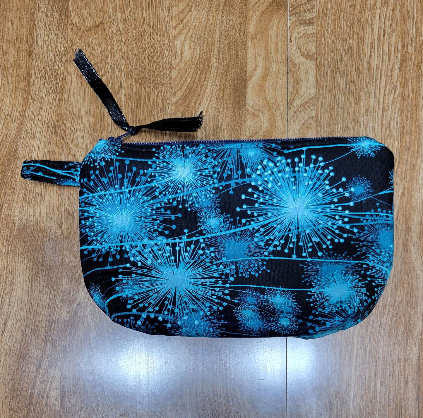 Make-up bag light blue with wish flowers on a dark blue background. 