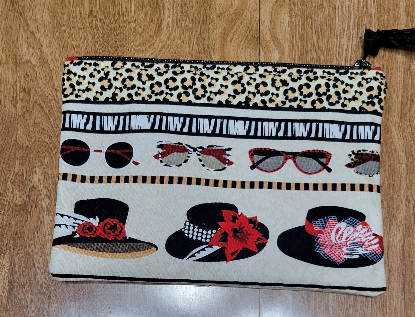 Hats and Sunglasses patterned pouch on a wooden surface