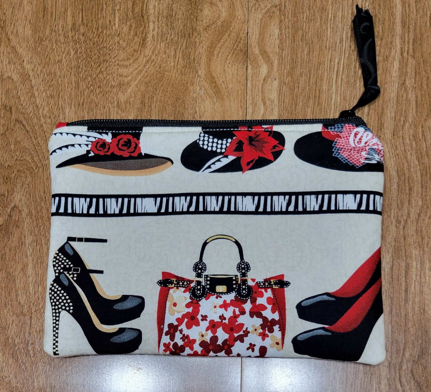 Pouch with shoe and handbag design on a wooden surface