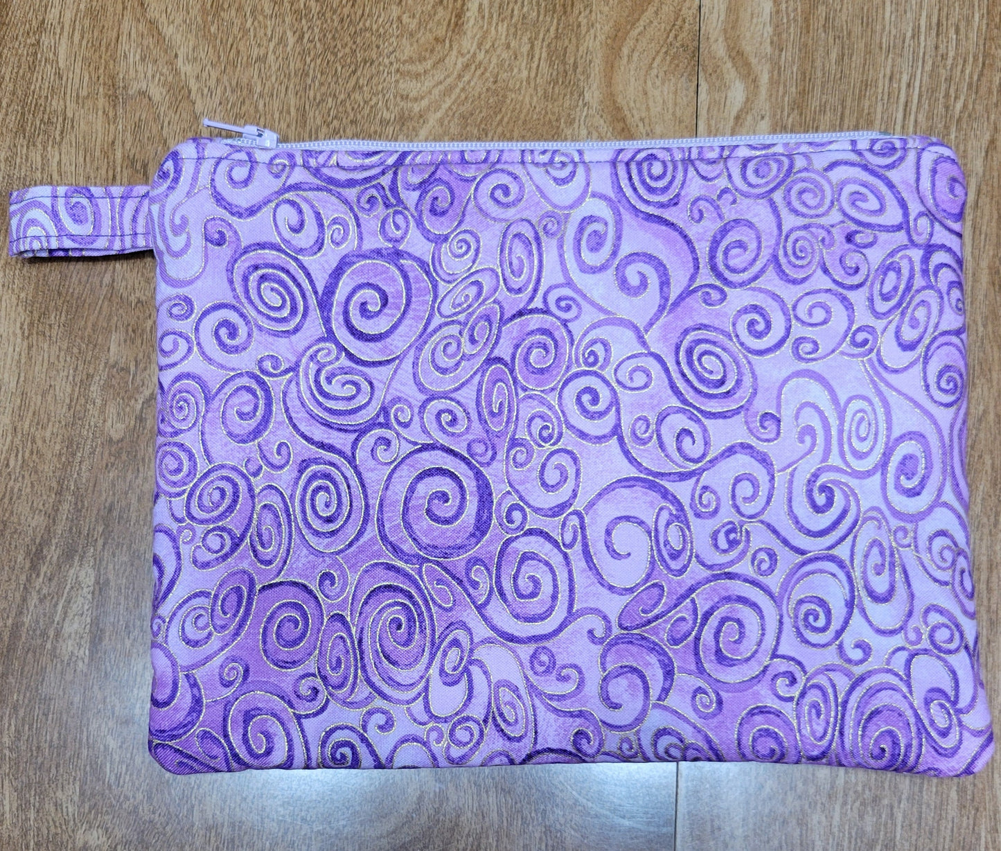Purple fabric pouch with swirl pattern on a wooden surface