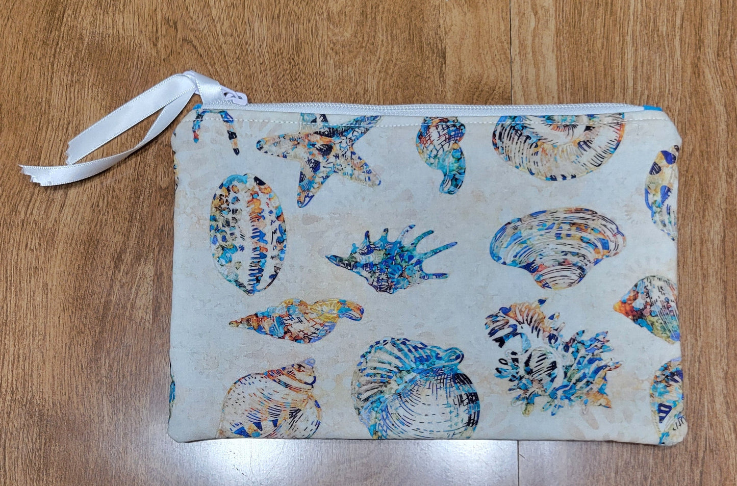 Fabric pouch with shell pattern on a wooden surface