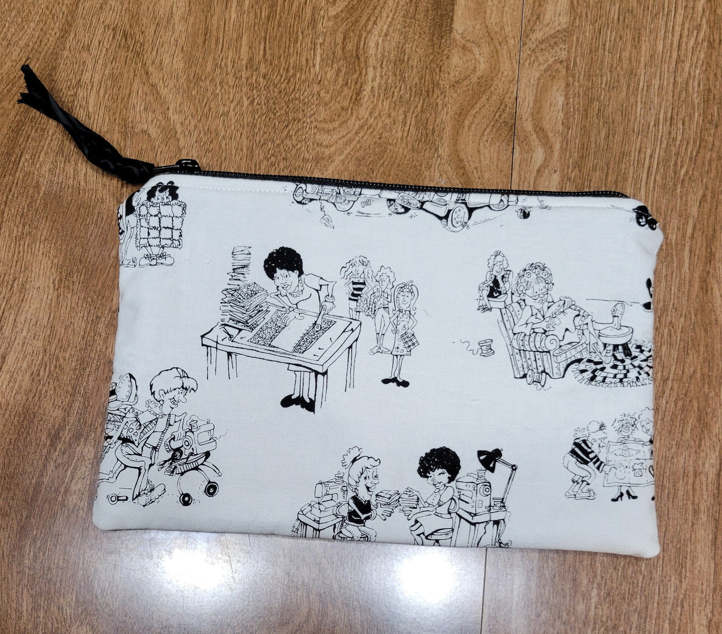 White pouch with black designs on a wooden surface