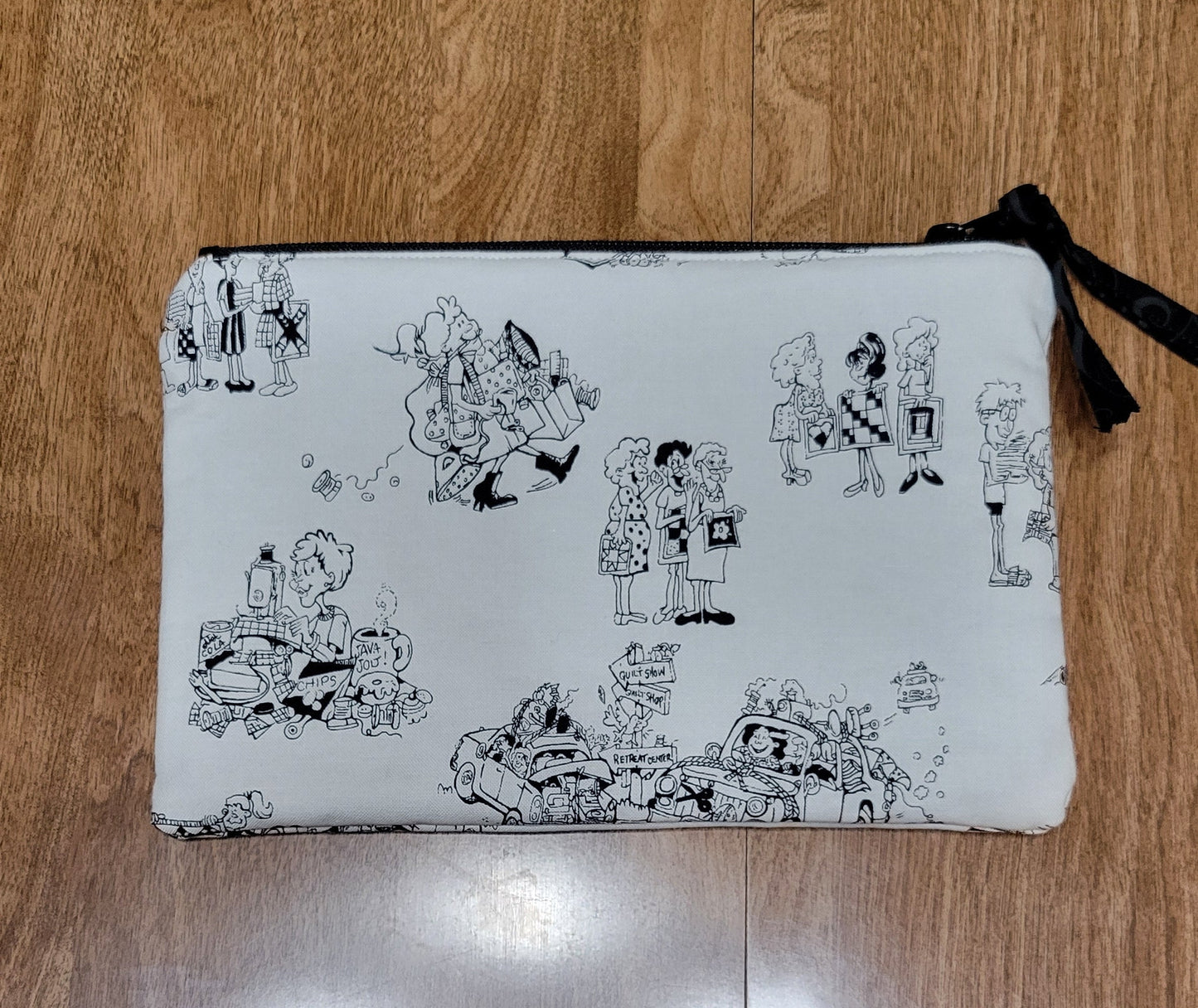 White pouch with black patterns on a wooden surface