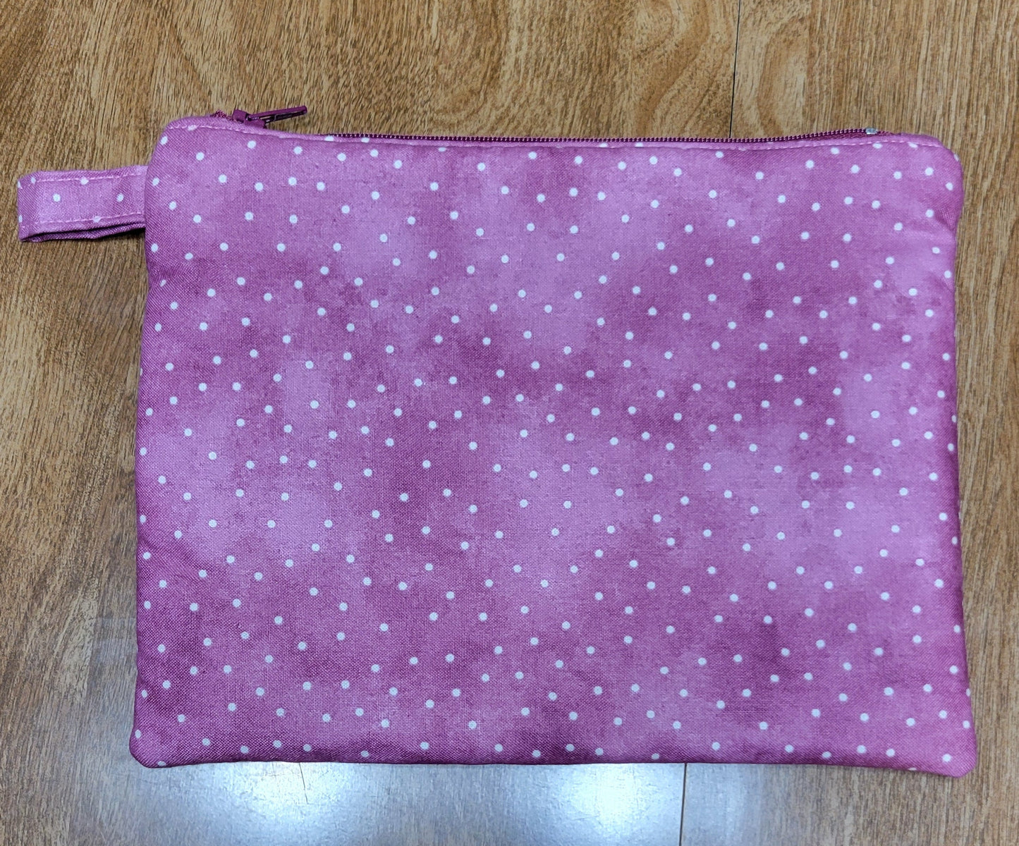 Purple fabric with white polka dots on a wooden surface