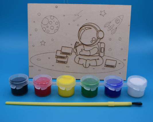 Children's craft kit with astronaut design on 3mm piece of wood, along with paints (black, red, yellow, green, blue and white are provided with a kids paint brush.